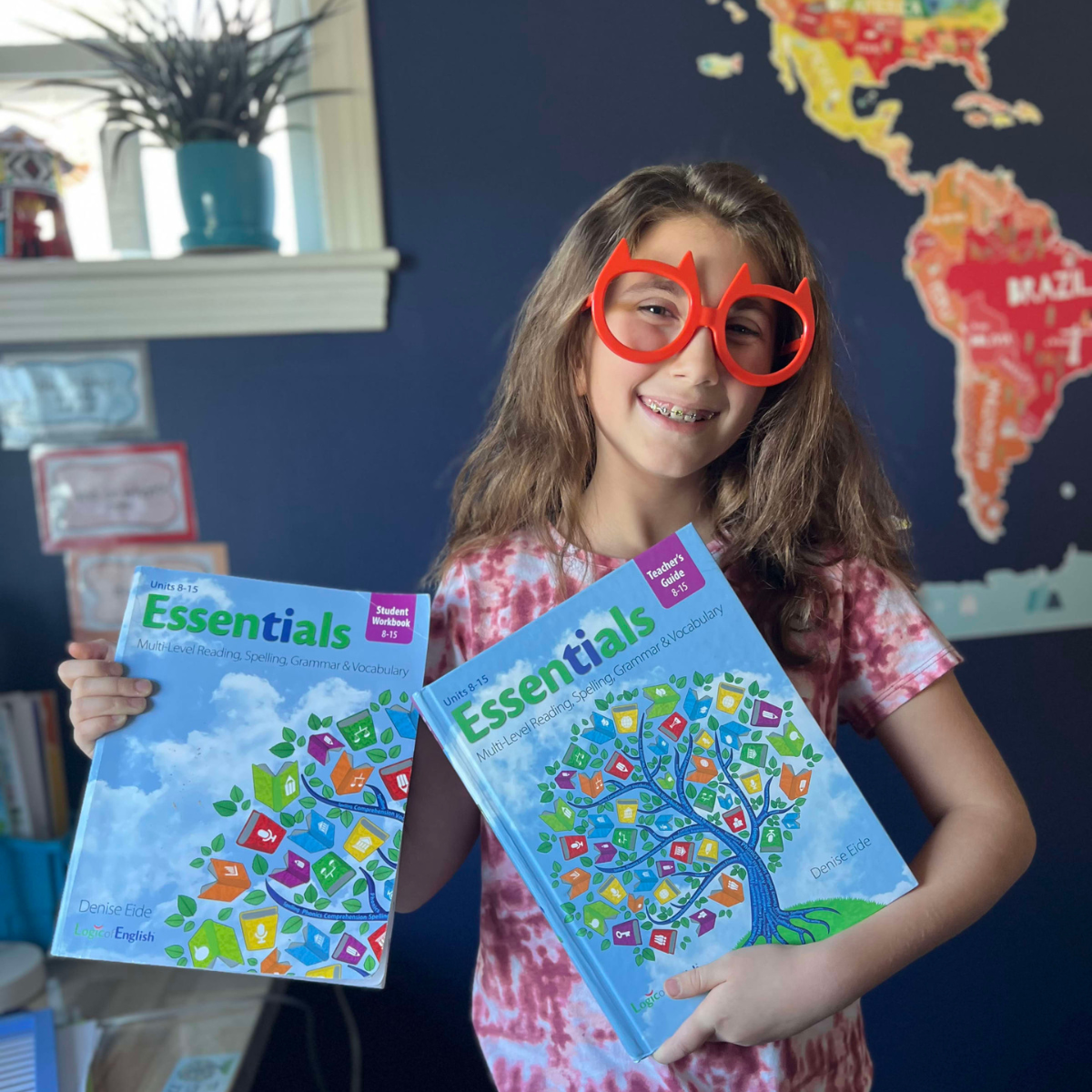 Student holding Essentials Teacher's Guide and workbook