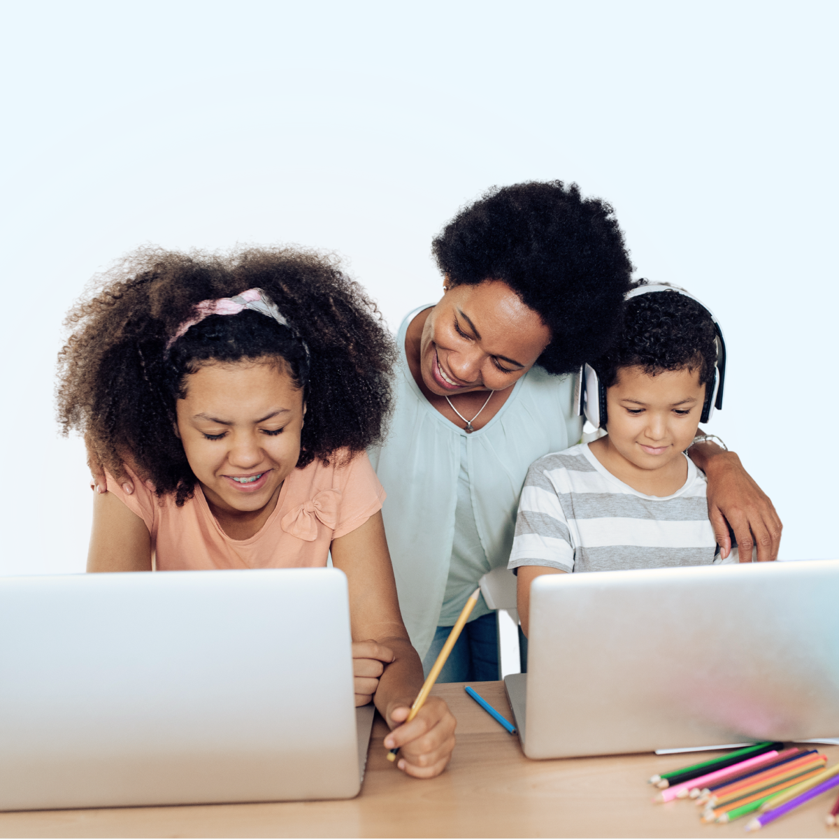 adult helping two students on computers