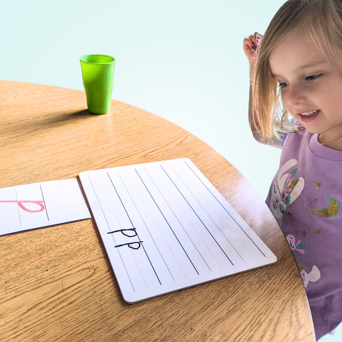 girl writing lowercase D on white board