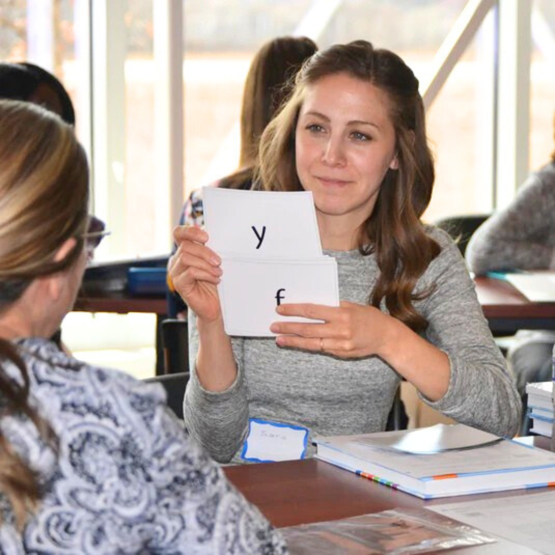teacher reviewing phonogram flashcards