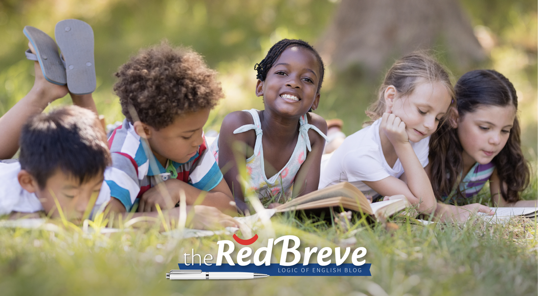 Happy children reading while resting on the grass