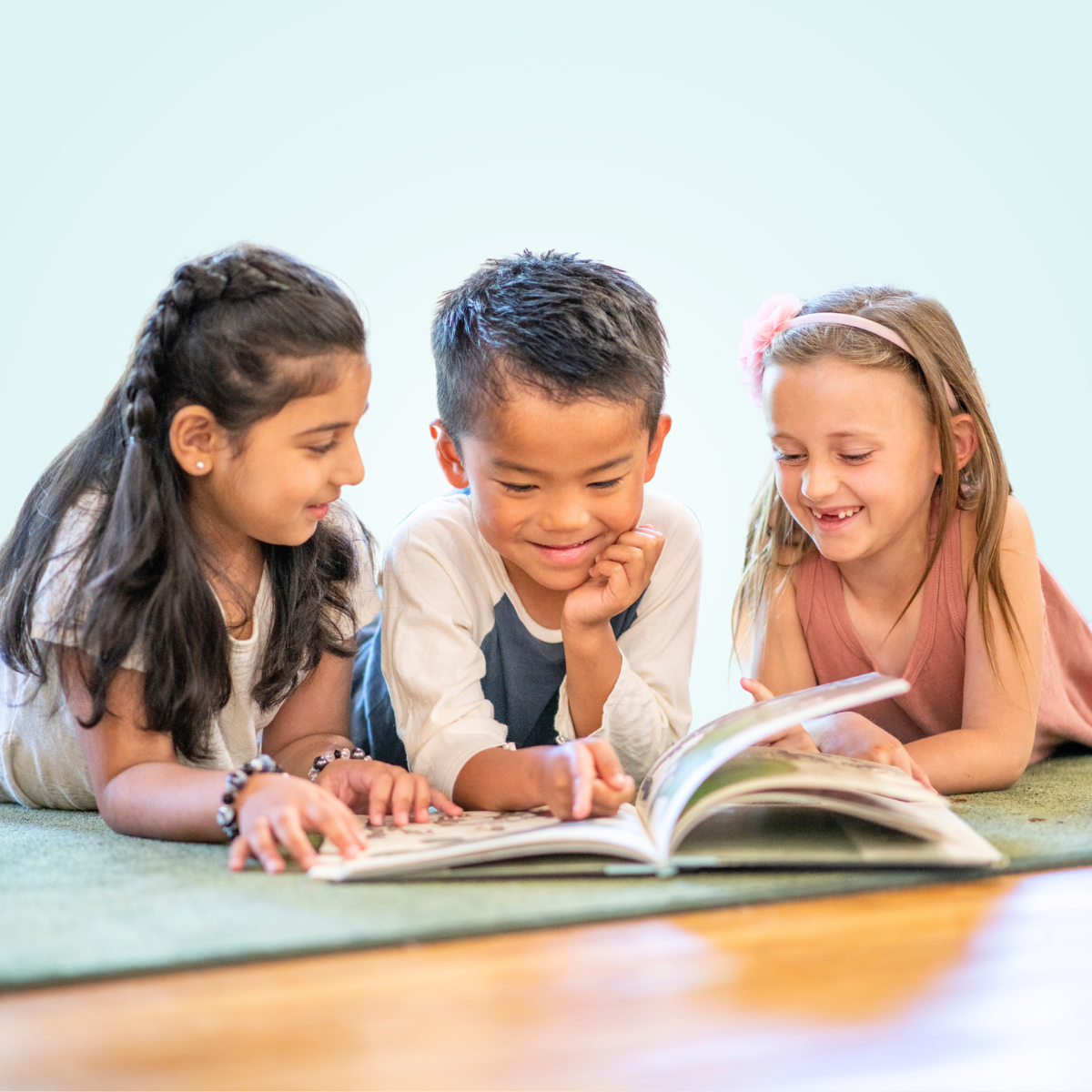 children smiling while reading book