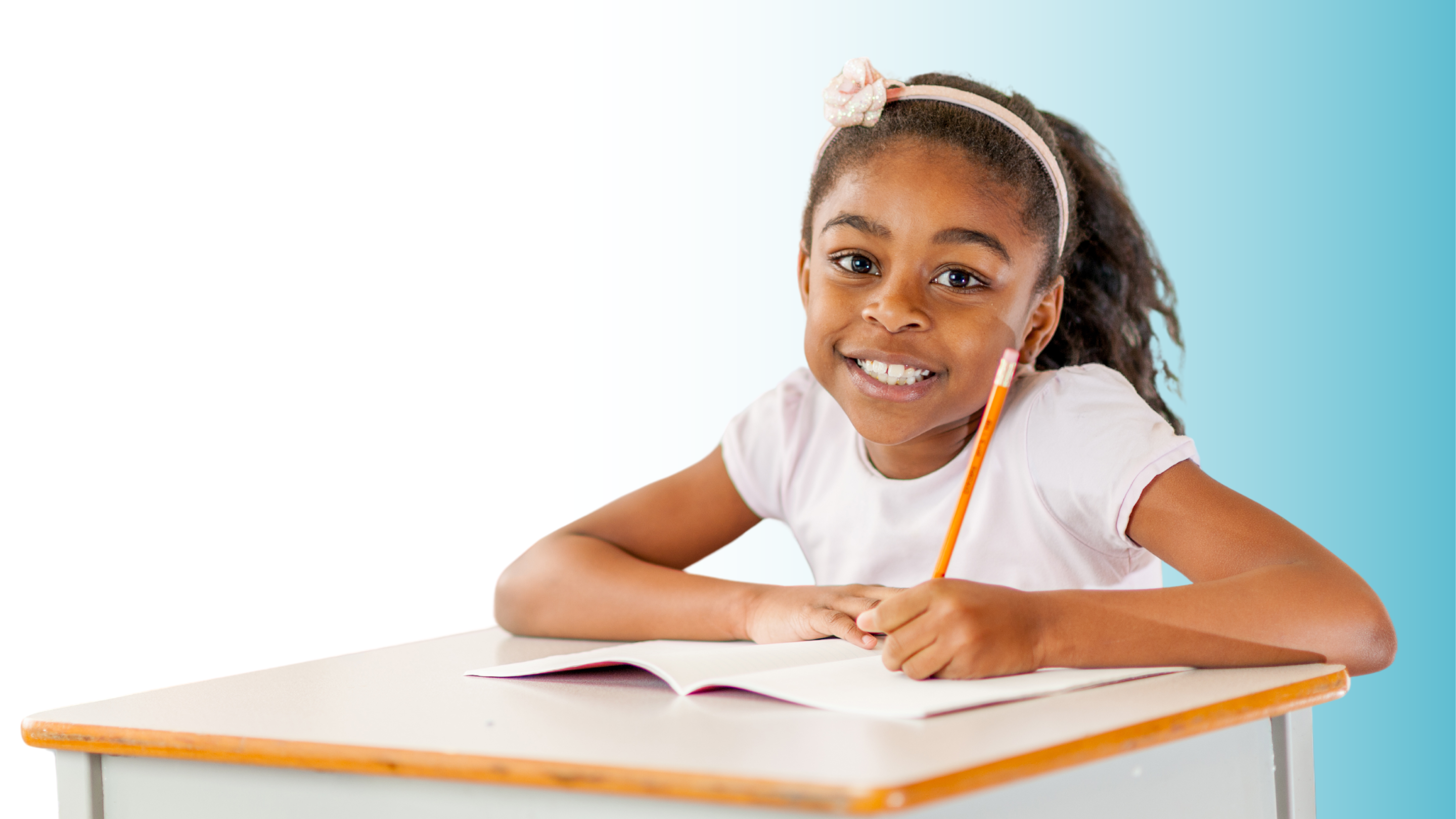 girl smiling at desk writing in notebook